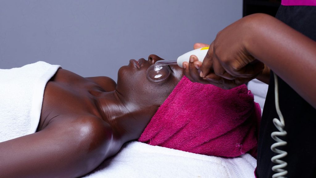a woman getting a facial massage with an electric device